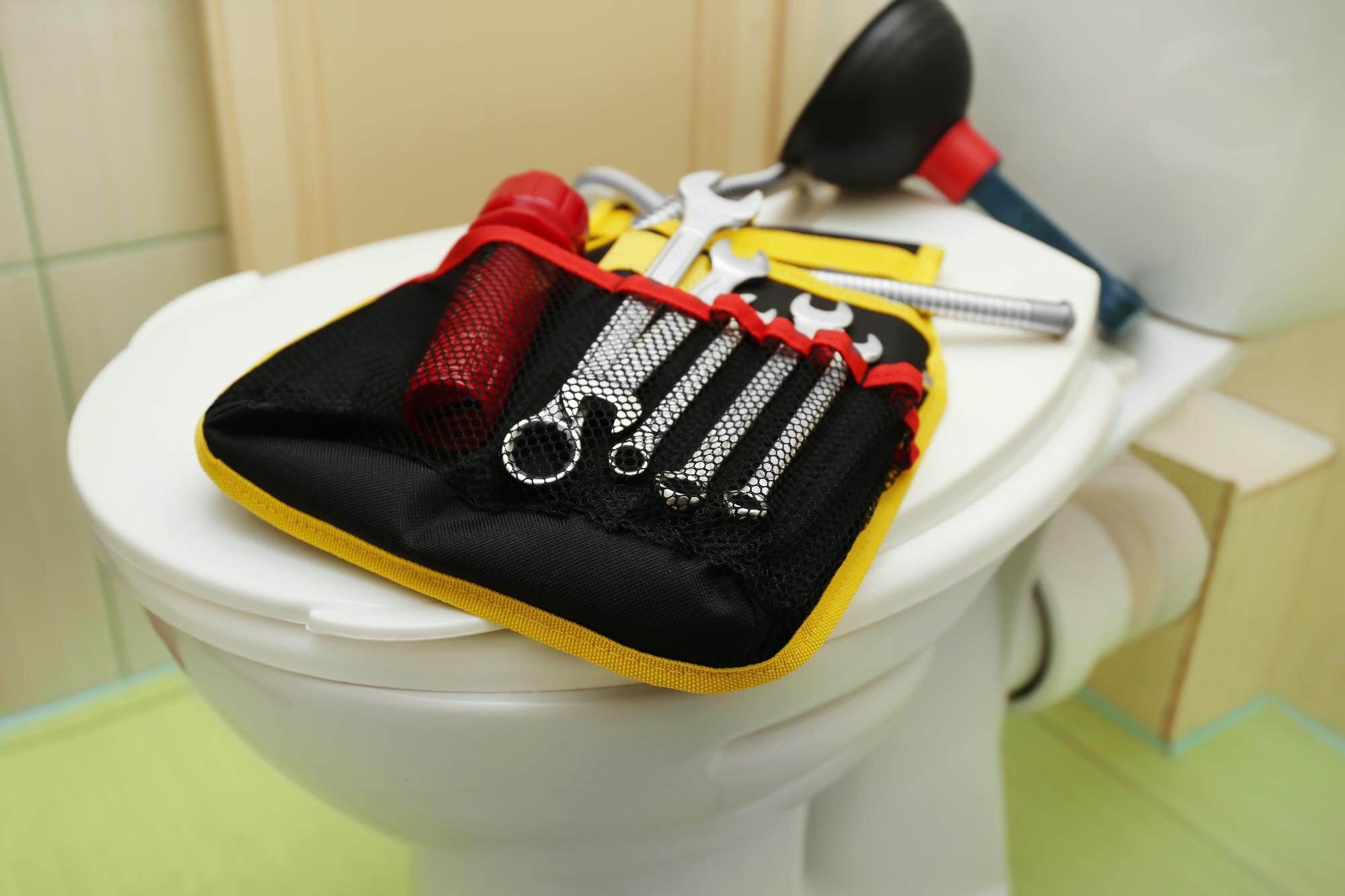 Narzędzia hydrauliczne na pokrywce siedzenia toalety w pomieszczeniach