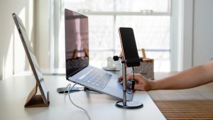 Modern Home Office Setup with Laptop Tablet and Smartphone on a White Desk