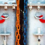 Wielobarwne łańcuchy z napiętymi hakami podtrzymują stalowe konstrukcje