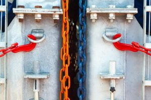 Wielobarwne łańcuchy z napiętymi hakami podtrzymują stalowe konstrukcje
