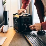 Freelancer man using charging station at home white blackout