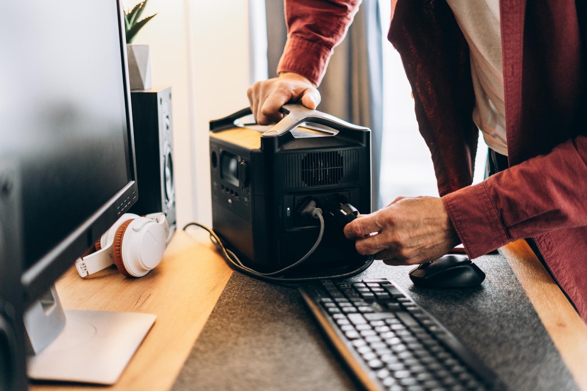 Freelancer man using charging station at home white blackout