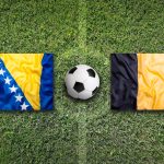 Bosnia and Herzegovina vs Belgium flags on soccer field