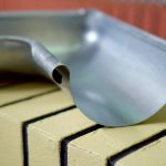 metal and plastic roof fastening elements gutter holders hooks and downpipes factory production industrial manufacturing process roofing components construction materials closeup metalworking