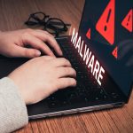 Kobieta korzystająca z laptopa z ostrzeżeniem o wirtualnym złośliwym oprogramowaniu Koncepcja zhakowania systemu Cyberatak na komputer