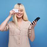 Blondynka europejska młoda kobieta z kartą kredytową i smartfonem