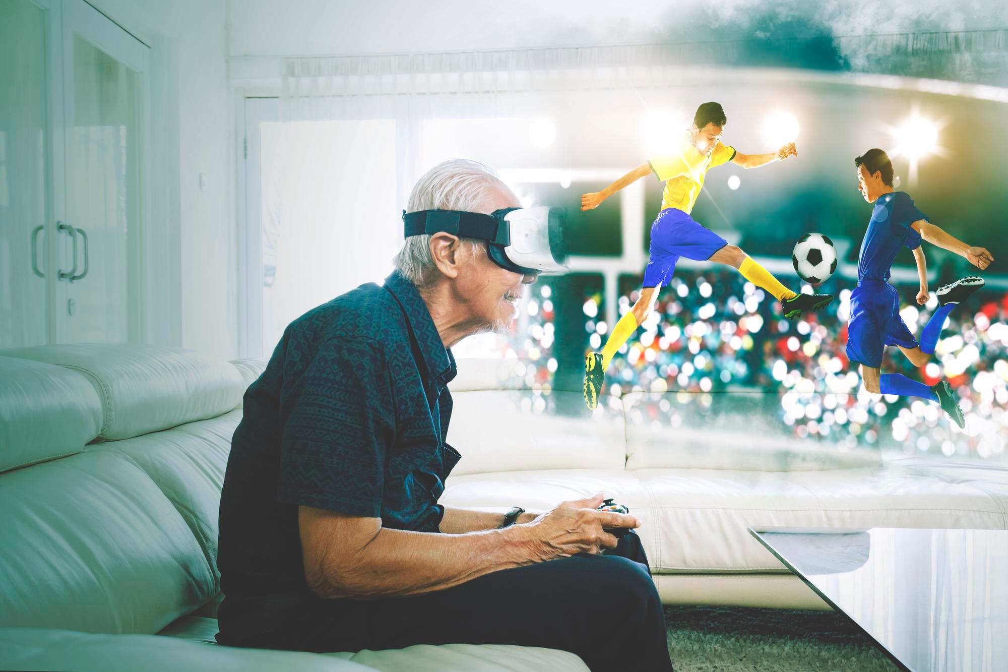 Stary człowiek grający w mecz piłki nożnej na okularach VR