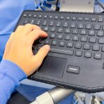 Osoba korzystająca z klawiatury ze słowem komputer u góry