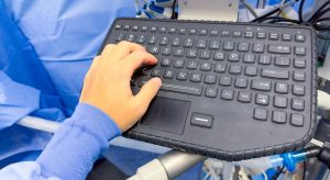 Osoba korzystająca z klawiatury ze słowem komputer u góry