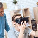 Ojciec stoi za niespokojnym nastolatkiem.