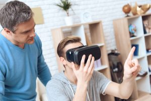 Ojciec stoi za niespokojnym nastolatkiem.