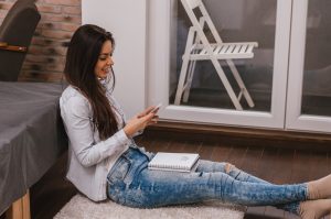 Dziewczyna siedzi w domu i pisze wiadomość