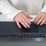 Brunetka blogerka pisze na laptopie