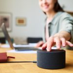 Kobieta używająca inteligentnego głośnika w domu