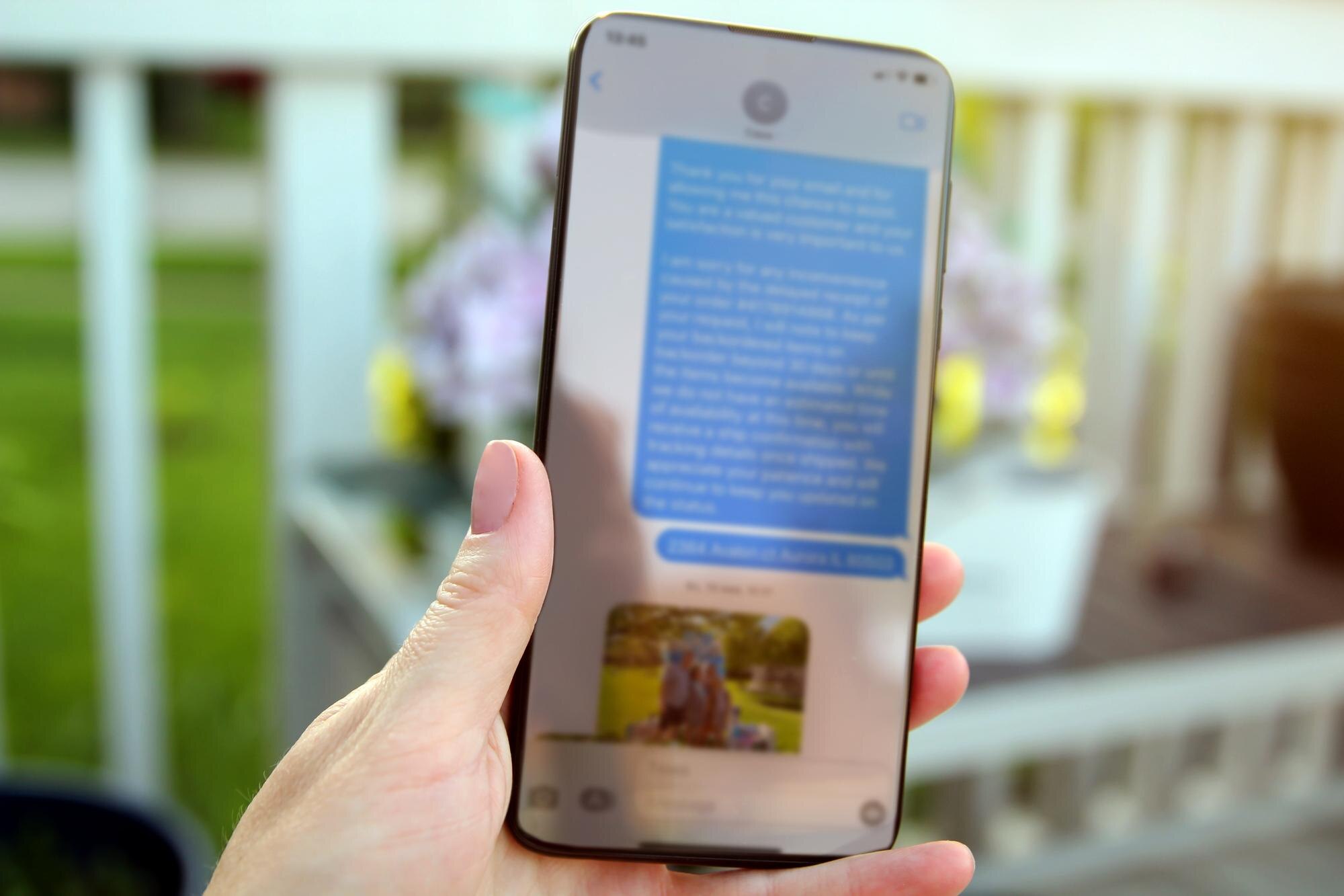 Kobieta sprawdza wiadomości tekstowe, trzymając smartfon na zewnątrz
