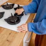 Kobieta wyciera powierzchnię do gotowania w kuchni