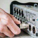 Ręka mężczyzny łącząca żeński kabel XLR