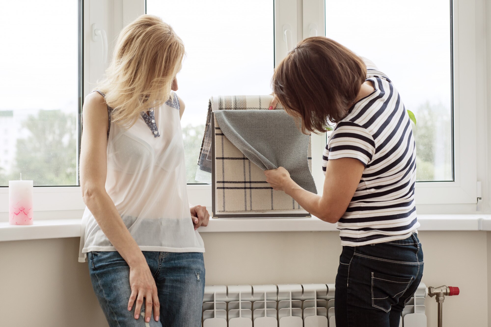 Projektant wnętrz pokazuje próbki tkanin i akcesoriów na zasłony w nowym domu