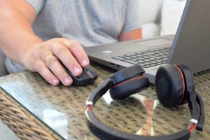 Mężczyzna pracuje na laptopie w domu Słuchawki leżą na stole w pobliżu