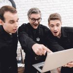 Funkcjonariusze policji patrzą na laptopa razem.
