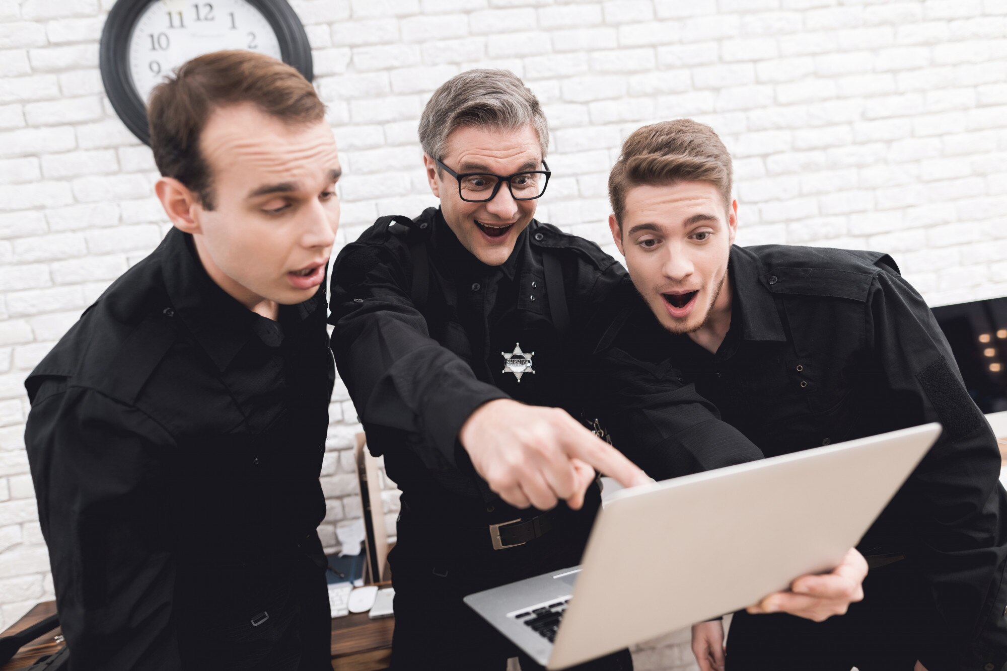 Funkcjonariusze policji patrzą na laptopa razem.