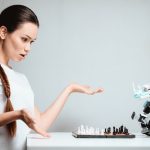 Dziewczyna bawi się z robotem w szachy.