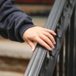 Ręka jest na balustradzie czarnej balustrady.