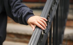 Ręka jest na balustradzie czarnej balustrady.