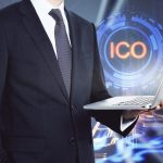 Biznesmen z laptopem stojącym na tle hologramu ICO uruchomienie i koncepcja decentralizacji