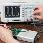 Inżynier ręce mierzy sygnały na pokładzie urządzenia elektronicznego