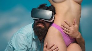 Świat erotycznej rzeczywistości wirtualnej Brodaty mężczyzna w zestawie słuchawkowym rzeczywistości wirtualnej przytulający seksi topless kobietę Hipster noszący urządzenie rzeczywistości wirtualnej dotykający ciała seksownej dziewczyny Gry wirtualnej rzeczywistości dla dorosłych