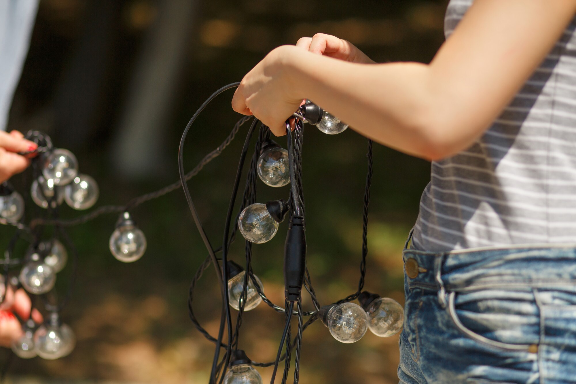 Dekoratorzy przygotowują i rozwiązują czarne druty girlandy lampowej żarówki