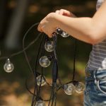 Dekoratorzy przygotowują i rozwiązują czarne druty girlandy lampowej żarówki