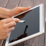 Kobieta trzyma cyfrową pastylkę, zbliżenie