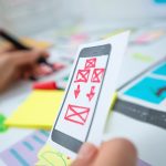 Projektant stron internetowych opracowuje aplikację na telefony komórkowe. Tworzenie układu funkcji interfejsu użytkownika smartfonów.