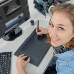 Młoda kobieta projektant za pomocą tabletu graficznego do edycji wideo