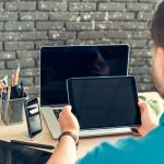 Młody człowiek biznesmen siedzi przy swoim stole roboczym w biurze