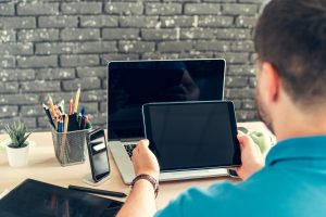 Młody człowiek biznesmen siedzi przy swoim stole roboczym w biurze