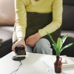 Ładowanie baterii telefonu komórkowego za pomocą bezprzewodowego urządzenia do ładowania w stole Ładowanie smartfonu na poduszce do ładowania Telefon komórkowy w pobliżu ładowarki bezprzewodowej