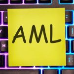 AML PRZECIW PRANIE PIENIĘDZY jest napisane na żółtej naklejce na klawiaturze laptopa z podświetleniem