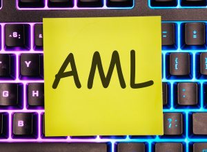 AML PRZECIW PRANIE PIENIĘDZY jest napisane na żółtej naklejce na klawiaturze laptopa z podświetleniem