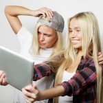 Dwie hipsterskie przyjaciółki robią sobie selfie z cyfrowym tabletem
