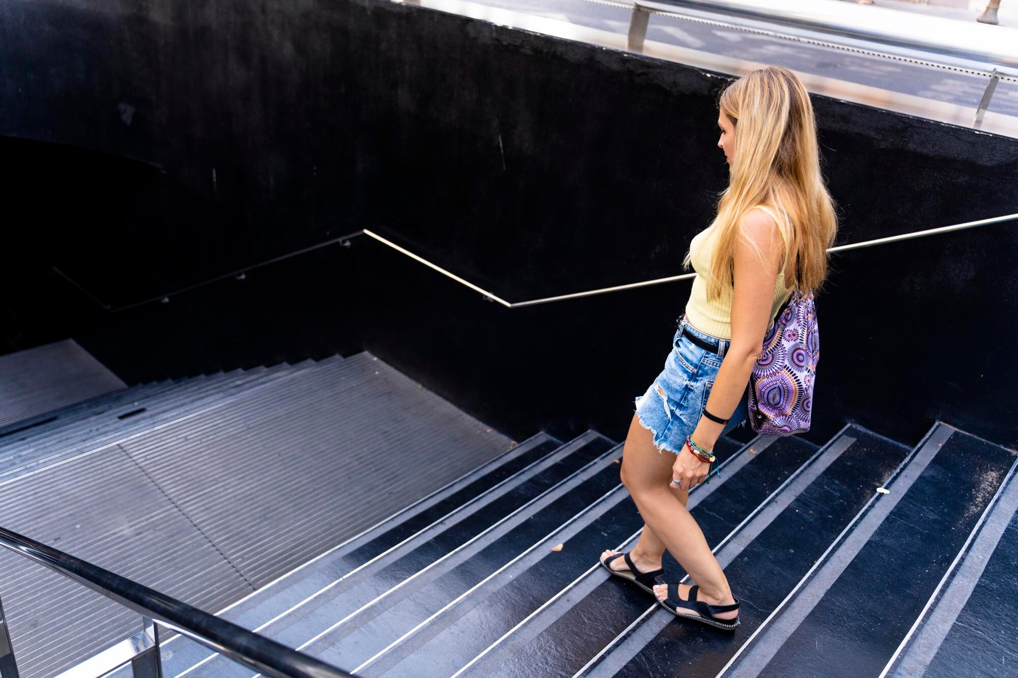 Nowoczesna blondynka wchodząca do wejścia do metra