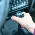 Zamyka w górę ręki kierowcy trzyma samochodowego ręcznego trasmission kij