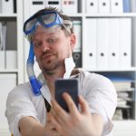 Mężczyzna w garniturze i krawacie w okularach ochronnych i snorkelu