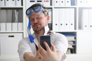 Mężczyzna w garniturze i krawacie w okularach ochronnych i snorkelu