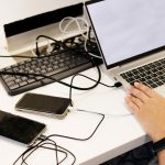 Młoda kobieta w ciąży ze słuchawkami na żółtym tle