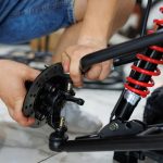 Pracownik robi ATV w warsztacie. Przygotowuje quad do sprzedaży