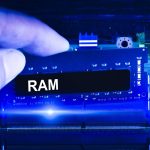 Technik ręcznie wkłada pamięć RAM do gniazda pamięci na płycie głównej komputera Technik uaktualnia pamięć RAM do niebieskiego odcienia laptopa Koncepcja technologii komputerowej