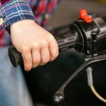 Zbliżenie dłoni dziecka na rączce starego motocykla